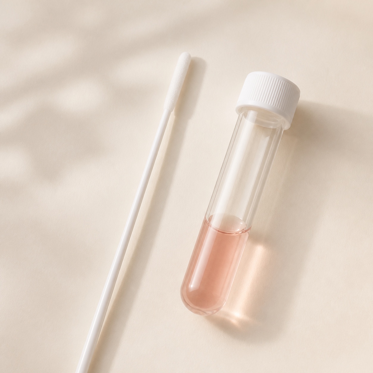 Sterile cheek swab beside a specimen tube with collection liquid
